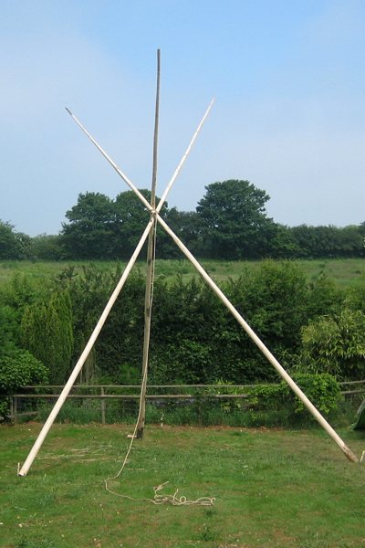 tipi construction stage 1 - 3 tipi poles being erected
